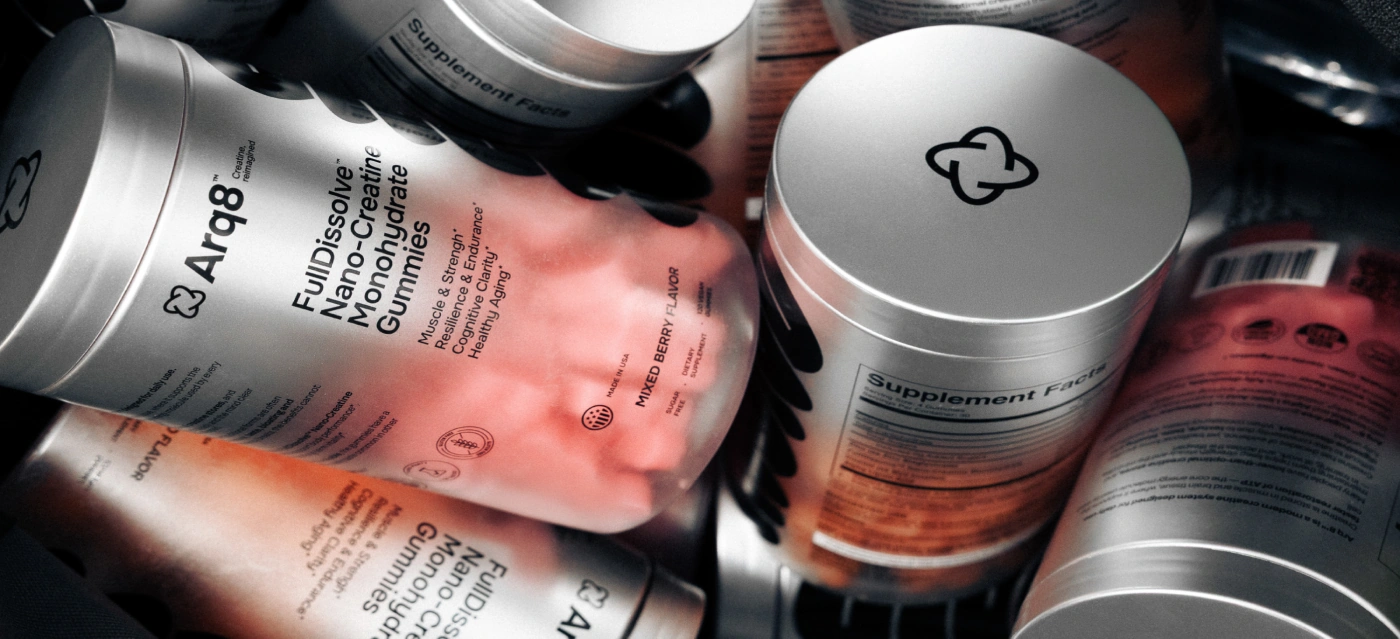 Silver supplement tins of creatine gummies piled together